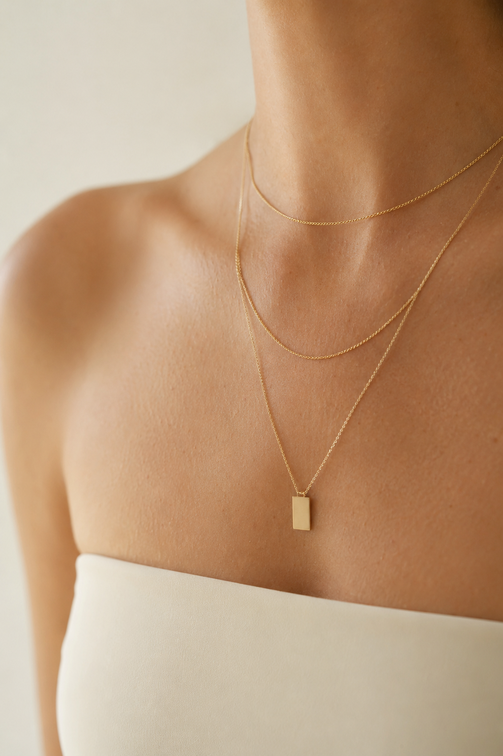 Décolleté portant trois colliers en chaîne dorée superposés