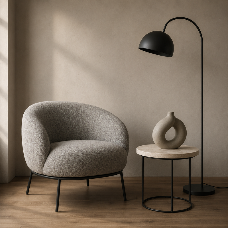 Intérieur contemporain : fauteuil arrondi en tissu gris, métal noir fin et céramique greige