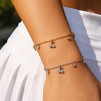 Bracelet à deux cerises suspendues sur chaîne fine dorée