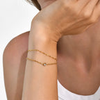 Bracelet chaîne très fine ponctuée de zircons, acier doré