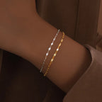 Bracelet jonc lisse en acier inoxydable doré porté au poignet