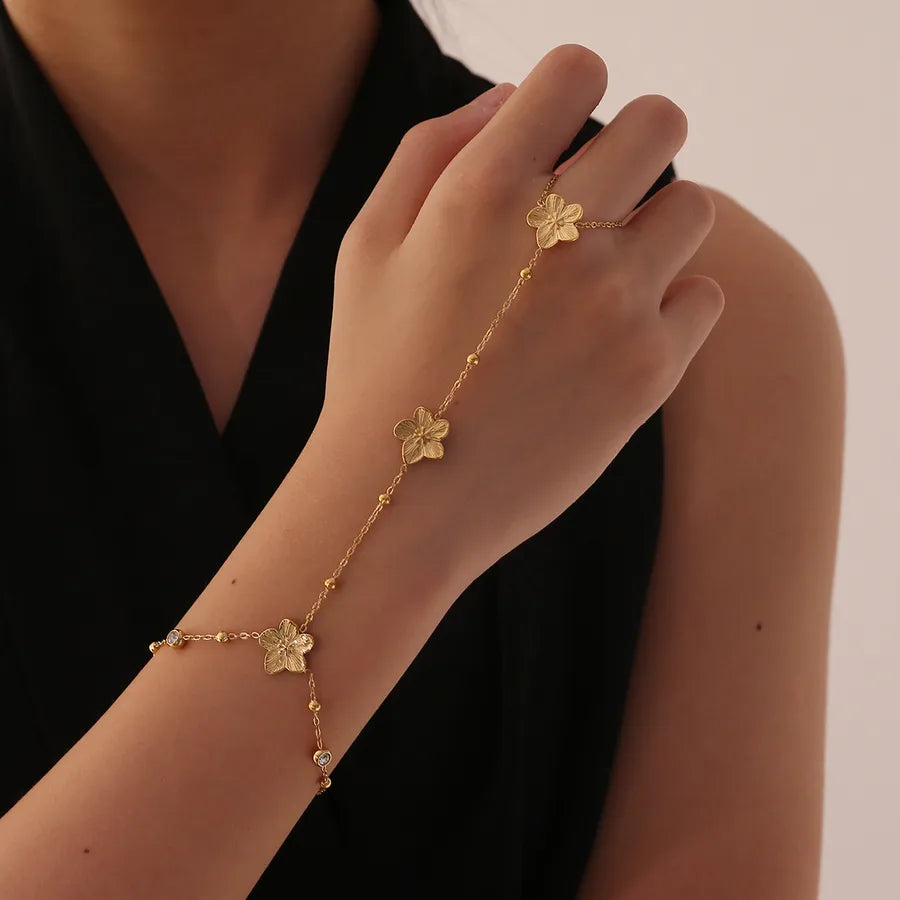 Bracelet de main à fleur pavée de zircons, acier doré